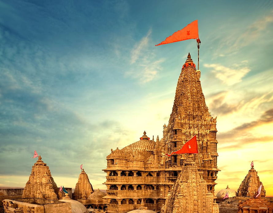 Dwarkadhish Temple at Golden Hour with Red Flags and Intricate Carvings HD wallpaper