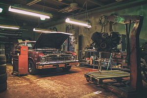 Vintage Muscle Car Under Repair in a Classic Auto Workshop with Engine Hoist HD wallpaper