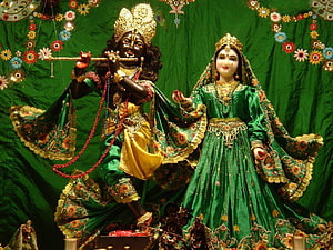 Radha Krishna Temple Murti in Ornate Green Silk Attire with Floral Decorations HD wallpaper