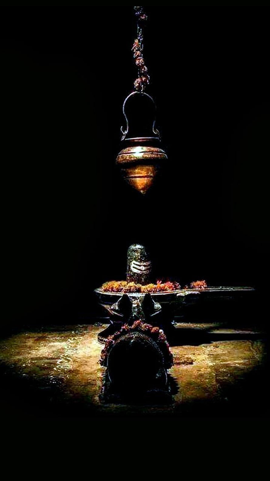 Sacred Shiva Lingam Ritual Setup with Hanging Oil Lamp and Marigold Garland HD phone wallpaper