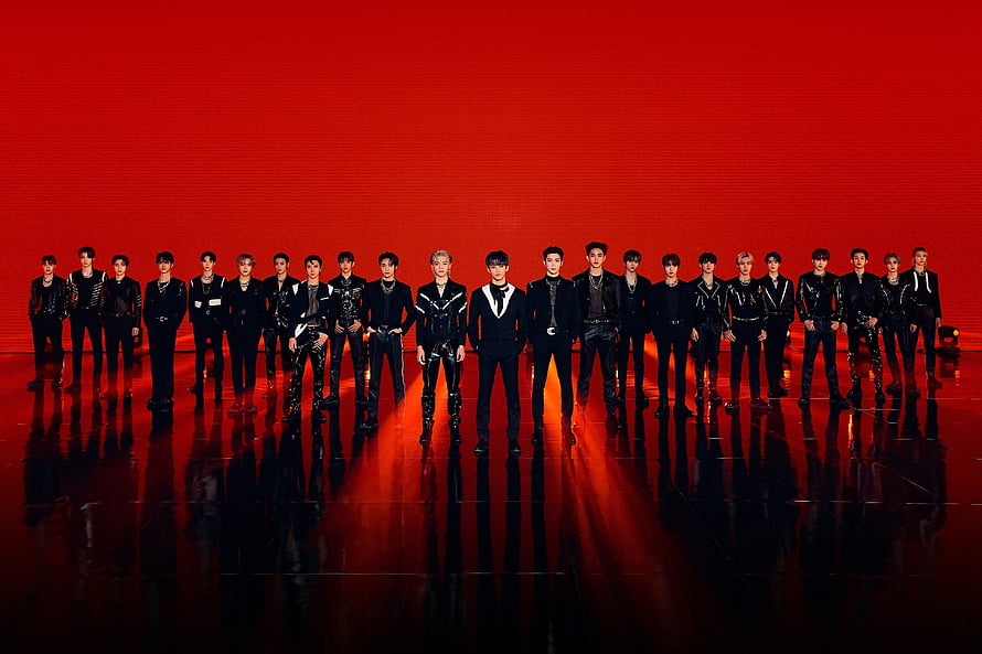 NCT 2020 and NCT 127 members in black stage outfits against a vivid red backdrop HD wallpaper