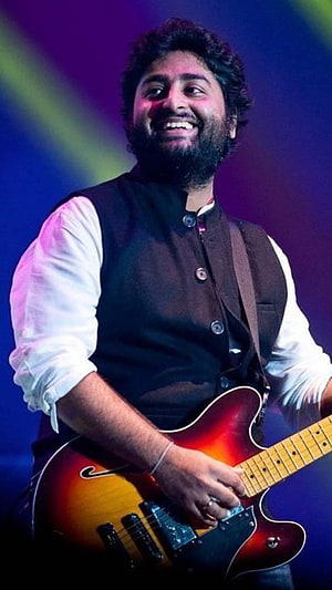Arijit Singh Playing Electric Guitar on Stage with Vibrant Lighting HD phone wallpaper