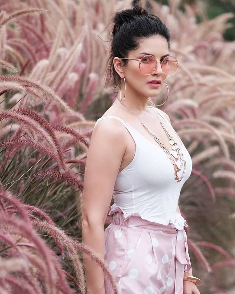 Sunny Leone in White Tank Top and Pink Polka Dot Skirt Amidst Pink Pampas Grass HD phone wallpaper