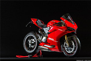 Red Ducati Panigale V4 S Superbike on Rear Stand Against Black Studio Background HD wallpaper