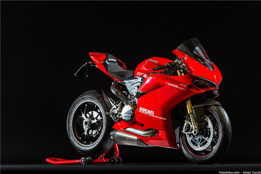 Red Ducati Panigale V4 S Superbike on Rear Stand Against Black Studio Background HD wallpaper