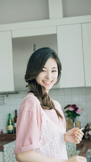 Tzuyu from TWICE smiling in a bright kitchen wearing a pink lace top HD phone wallpaper
