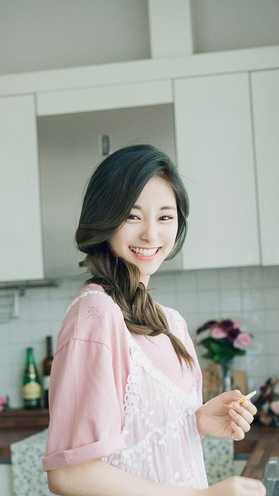 Tzuyu from TWICE smiling in a bright kitchen wearing a pink lace top HD phone wallpaper