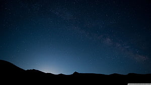 Milky Way Galaxy Arching Over Dark Mountain Silhouette at Night HD wallpaper