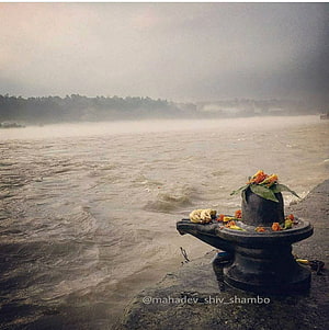 Sacred Shivling Adorned With Marigolds On The Banks Of A Misty River HD phone wallpaper