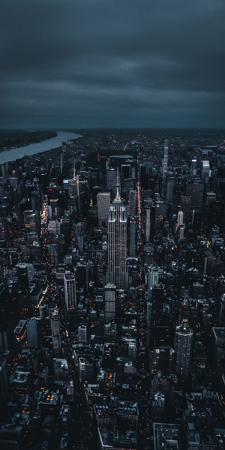 Aerial View of New York City at Night with Empire State Building Under Stormy Skies HD phone wallpaper