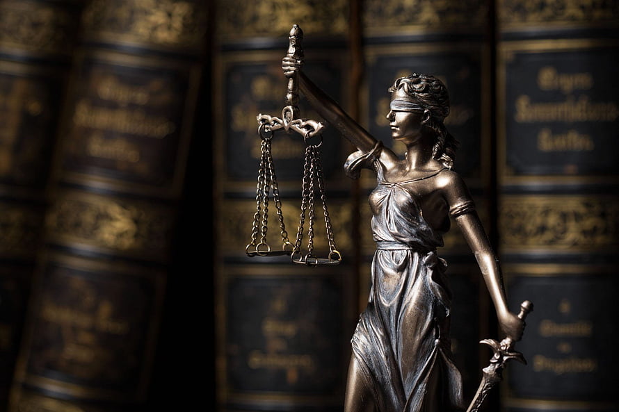 Bronze Statue of Themis Holding Scales and Sword in Front of Law Books HD wallpaper