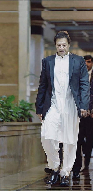 Imran Khan in White Shalwar Kameez and Dark Blazer Walking Indoors HD phone wallpaper