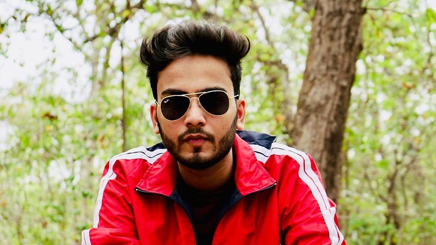 Elvish Yadav in Red Track Jacket and Aviator Sunglasses in a Forest Setting HD wallpaper