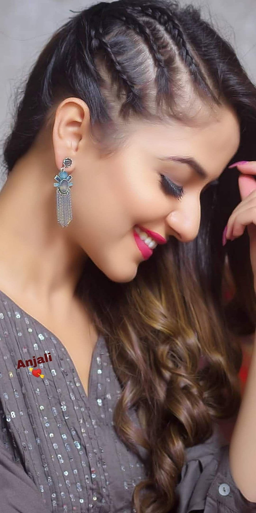 Smiling woman with braided hair and long wavy locks wearing statement earrings HD phone wallpaper
