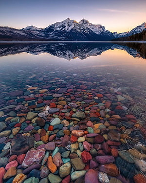 Lake McDonald Reflection at Dawn in Glacier National Park with Colorful Pebbles HD phone wallpaper