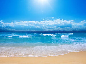 Serene Tropical Beach With Turquoise Waves And Golden Sand Under A Bright Blue Sky HD wallpaper