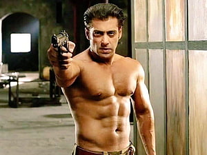 Salman Khan shirtless action scene from Radhe holding a pistol in a dimly lit interior HD wallpaper