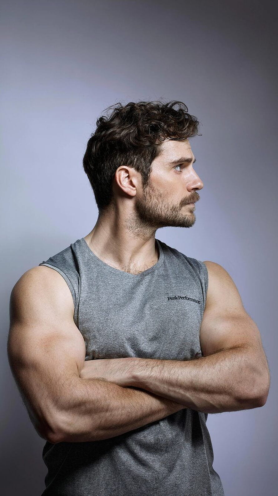 Henry Cavill in a grey tank top with arms crossed in a studio portrait HD phone wallpaper