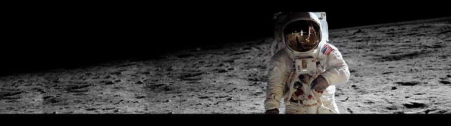 Astronaut in white spacesuit standing on the lunar surface with a black sky and reflective gold visor HD wallpaper