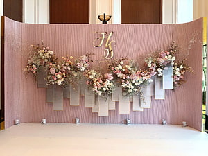 Elegant Blush Pink Wedding Stage Backdrop With Floral Arrangements And Gold Monogram HD wallpaper