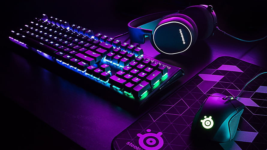 SteelSeries RGB Gaming Setup with Backlit Keyboard, Mouse, and Headset on Dark Desk HD wallpaper