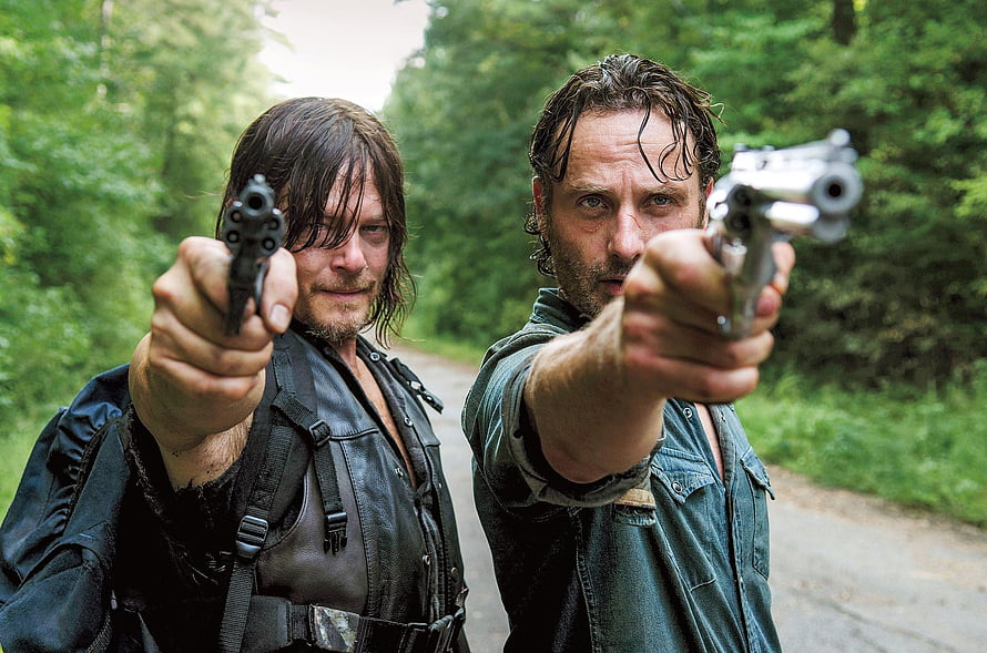 Daryl Dixon and Rick Grimes Aiming Firearms on a Forest Road in The Walking Dead HD wallpaper