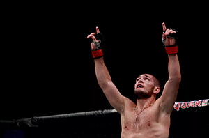 Khabib Nurmagomedov Celebrates Victory in UFC Octagon with Arms Raised HD wallpaper