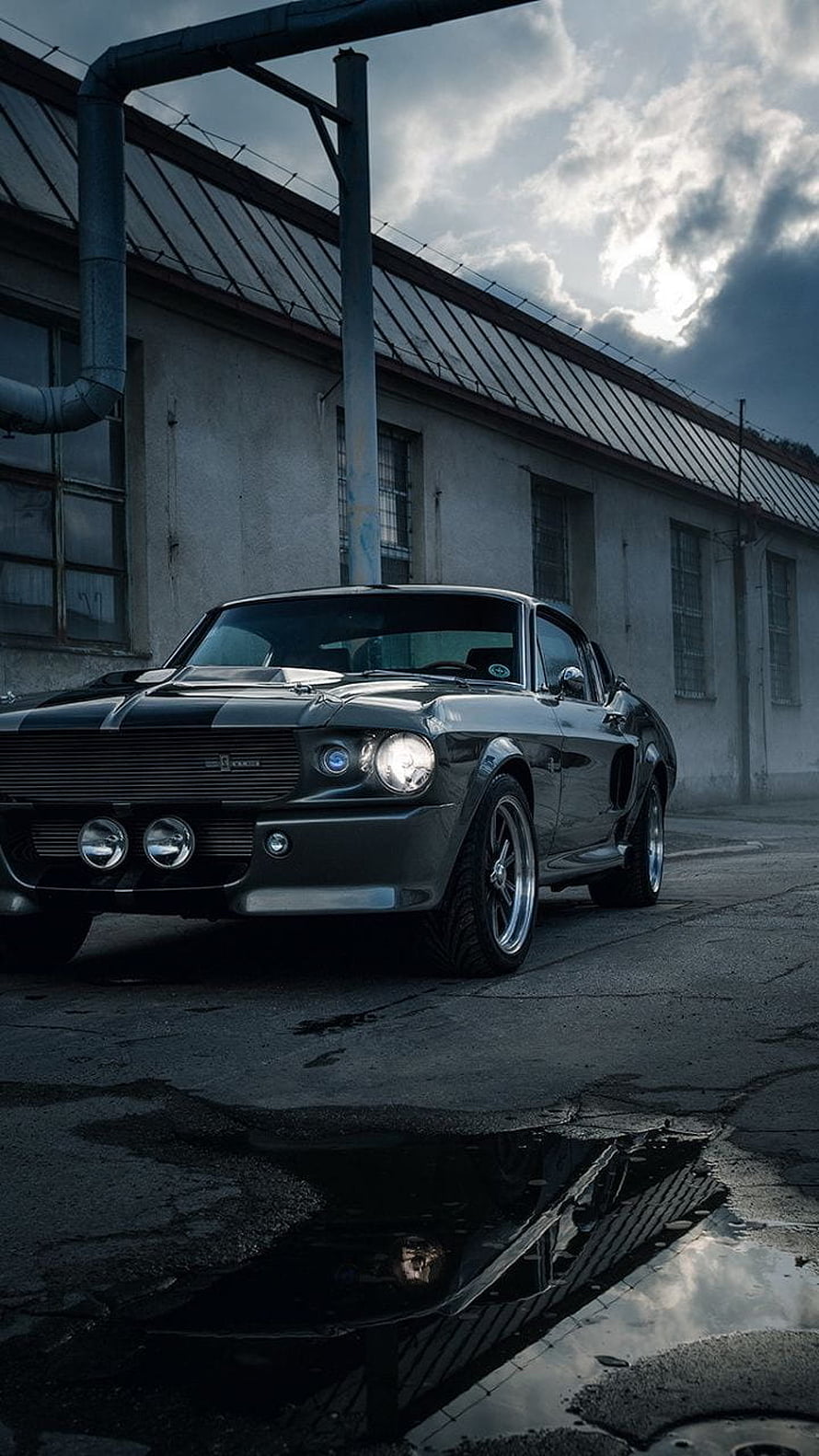Black Ford Mustang Shelby GT500 Eleanor parked in an industrial yard under a dramatic cloudy sky HD phone wallpaper