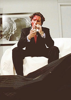 Patrick Bateman in a dark pinstripe suit with a bloodied face sitting on a white bed, American Psycho, patrick bateman HD phone wallpaper