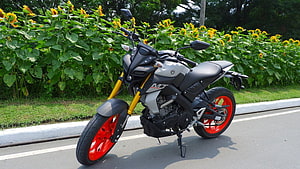 Yamaha MT-15 Motorcycle with Red Rims Parked on Roadside Near Sunflowers HD wallpaper