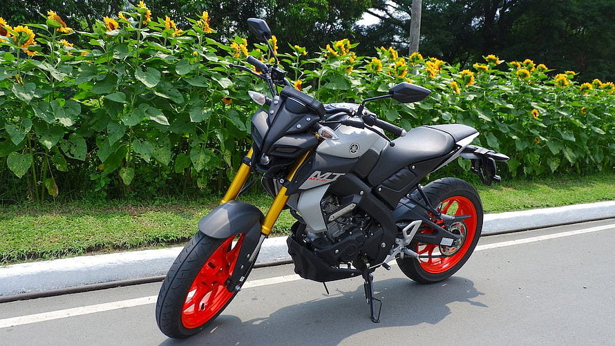 Yamaha MT-15 Motorcycle with Red Rims Parked on Roadside Near Sunflowers HD wallpaper