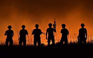 Silhouetted Soldiers Standing in a Field at Sunset with Rifles HD wallpaper