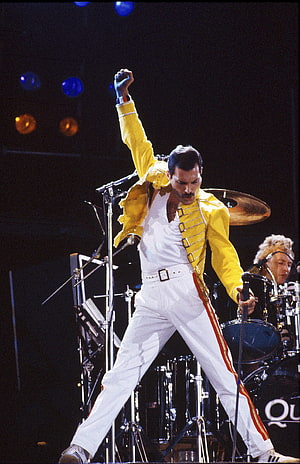 Freddie Mercury in Iconic Yellow Jacket and White Trousers on Stage HD phone wallpaper
