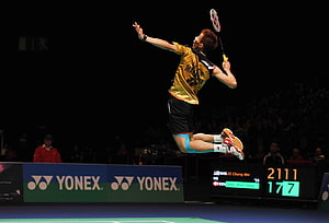 Lin Dan executing a powerful jumping smash in a Yonex sponsored badminton match HD wallpaper