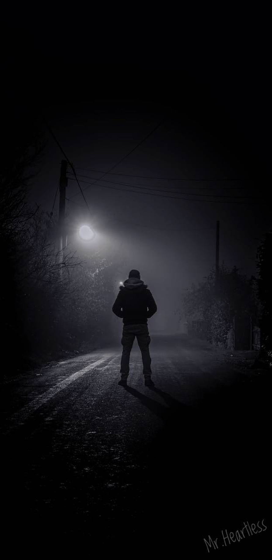 Solitary Figure Standing on a Dark Foggy Road at Night HD phone wallpaper