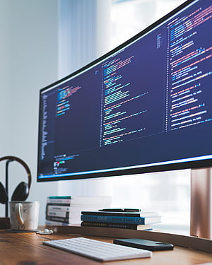 Curved Monitor Displaying Code in a Modern Developer Workspace HD phone wallpaper