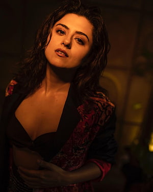 Ridhi Dogra moody portrait in warm amber lighting with patterned jacket HD phone wallpaper