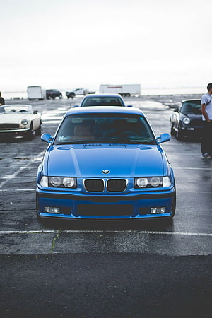 Front View of a Blue BMW E36 M3 Sedan Parked in an Outdoor Lot HD phone wallpaper