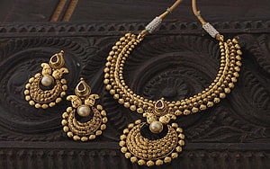 Traditional Indian Gold Jewelry Set With Pearl And Ruby Accents On Carved Wooden Surface HD wallpaper