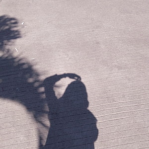 Minimalist Shadow of a Woman Wearing a Hijab on Textured Concrete Surface HD wallpaper