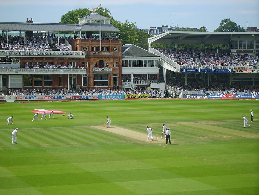 Lord's Cricket Ground with players in white on the pitch and packed stands under a clear sky HD wallpaper