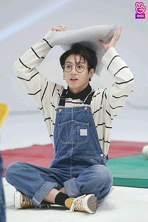 Jungkook in denim overalls and striped shirt holding a pillow HD phone wallpaper