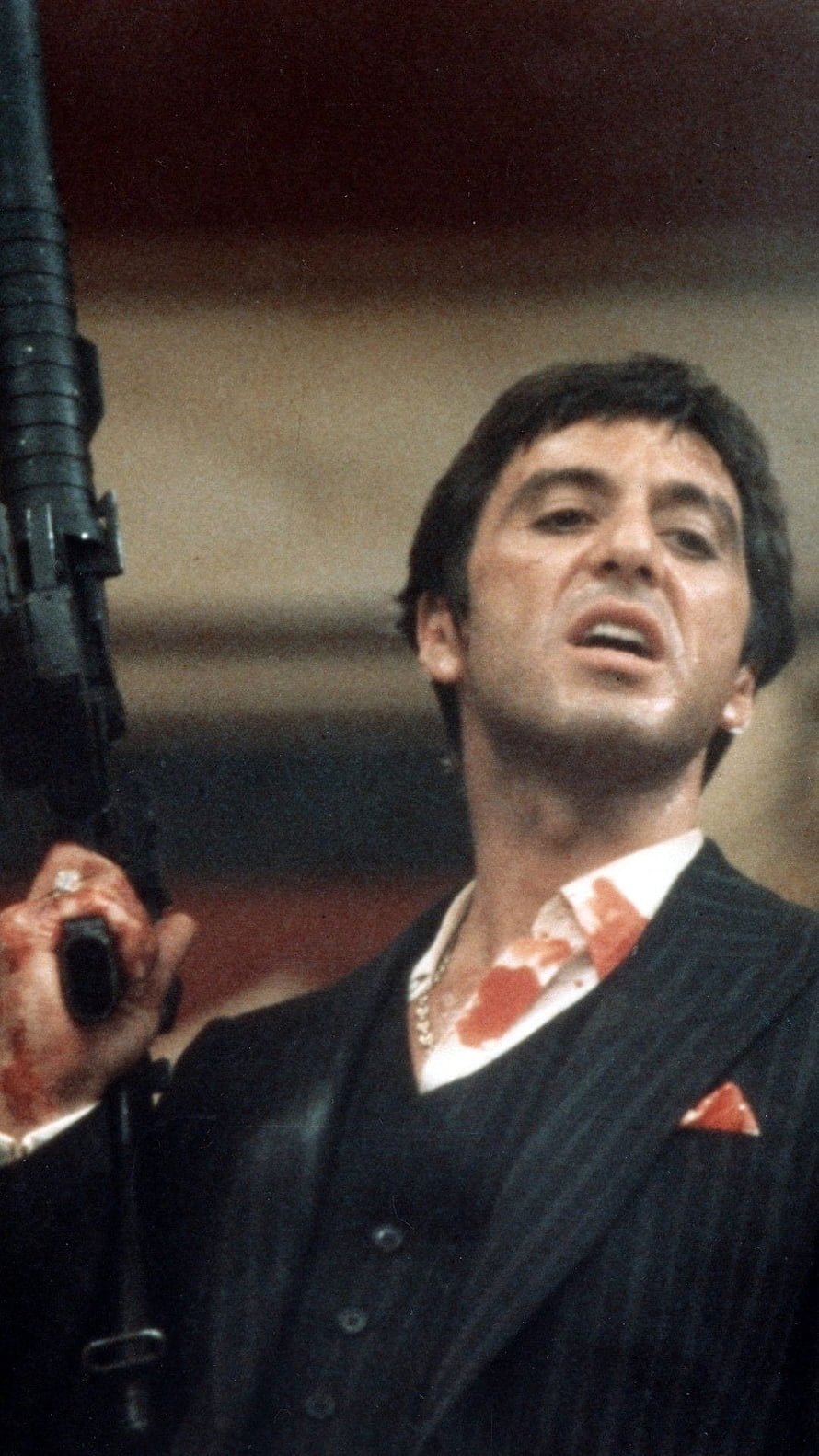 Tony Montana from Scarface holding a submachine gun in a blood-stained suit HD phone wallpaper