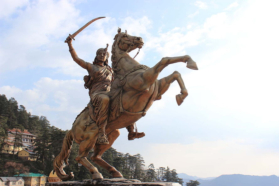 Rani Lakshmi Bai Equestrian Statue in Simla with Sword Raised Against a Mountain Sky HD wallpaper