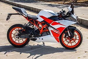 KTM RC 200 sport motorcycle in white and red with orange frame and wheels parked on a paved surface HD wallpaper