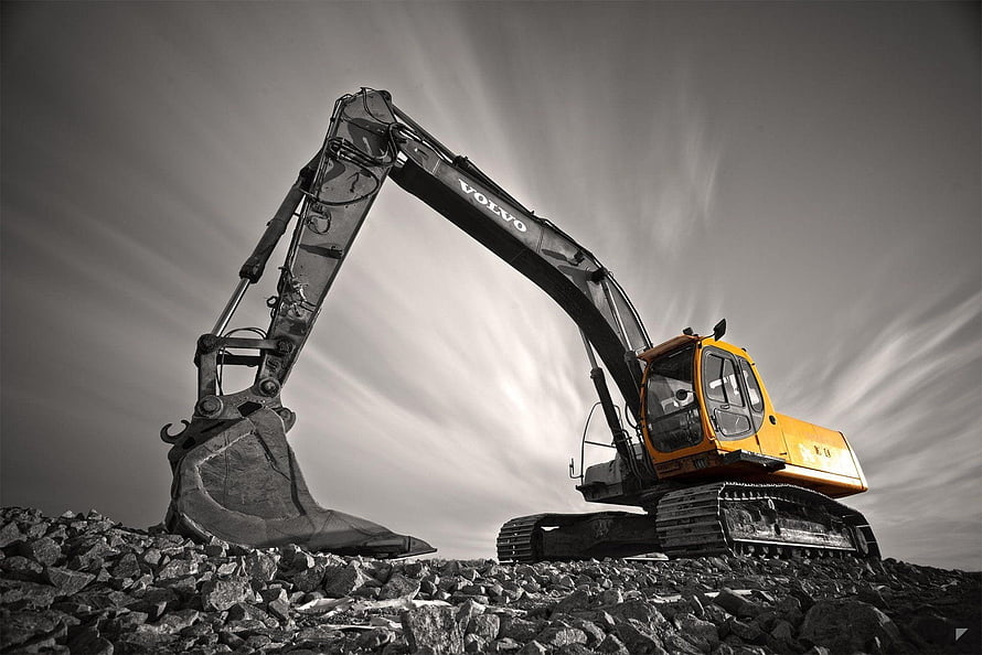 Volvo Excavator Digging Through Rocky Terrain Under Dramatic Sky HD wallpaper