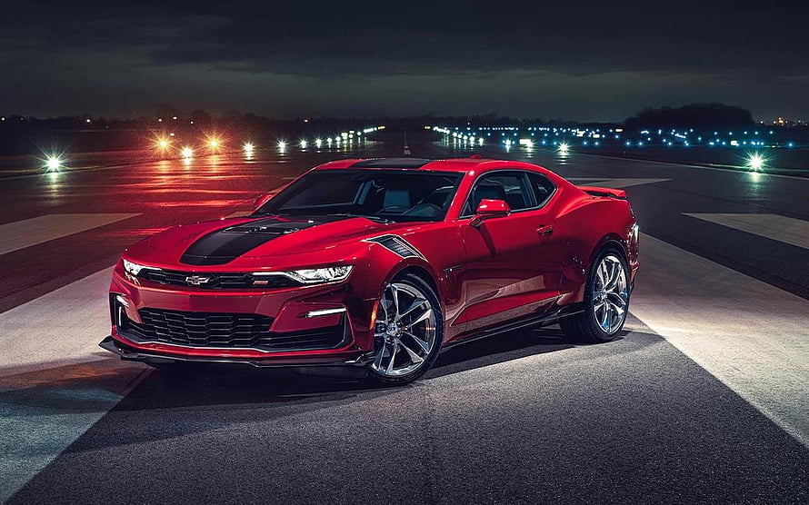 2022 Chevrolet Camaro ZL1 in red parked on a dark runway at night with city lights in the background HD wallpaper
