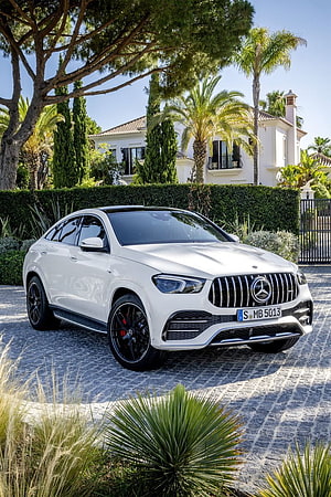 White Mercedes-AMG GLE Coupe parked in a Mediterranean courtyard with palm trees and a luxury villa HD phone wallpaper