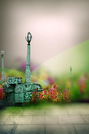 Ornate Green Stone Lamp Post in a Lush Garden with Vibrant Flowers and Soft Bokeh HD phone wallpaper