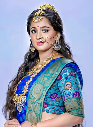 Anushka Shetty in Traditional Indian Saree with Gold Jewelry and Floral Motifs HD phone wallpaper